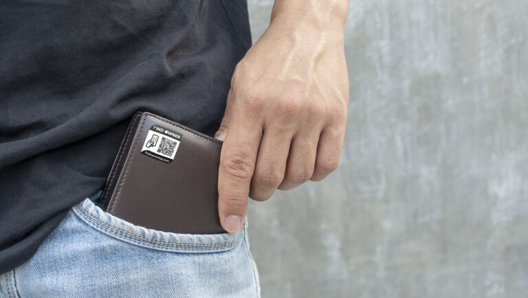 Men hold a brown wallet from a jeans pocket.
